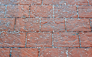 Spreading rock salt, keeping sidewalks slip-free all season long. Rock salt crystal sprinkled on...