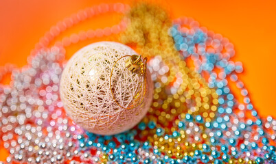 Christmas ball on a background of beads out in defocus.