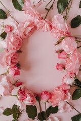 Round frame wreath with blank mockup copy space made of pink rose flowers on pink background. Flat lay, top view minimal floral composition.