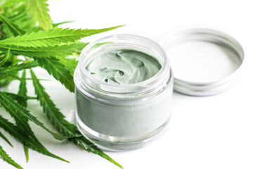  Green cannabis plant and jar with a moisturizing cream