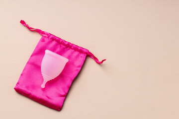 One menstrual cup on beige background top view
