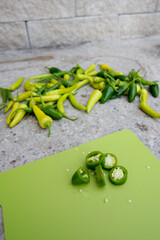 Cutting fresh home grown chillies on wooden board.