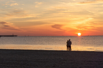 Silhouette of romantic couple watching sea sunset