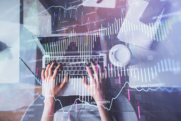 Double exposure of woman hands working on computer and forex chart hologram drawing. Top View. Financial analysis concept.