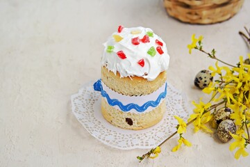 Traditional Easter cake decorated with sugar fondant and multi-colored candied fruits on a light concrete background. Easter concept. Festive Easter baking recipes.