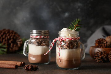 Two homemade edible Christmas gift in glass for making chocolate drink on dark background. - obrazy, fototapety, plakaty