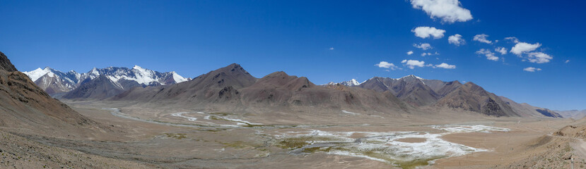 Panoramic view with pastel colors of mountains towards the north from high-altitude Pamir Highway at Ak Baital pass in Murghab district, Gorno-Badakshan, Tajikistan