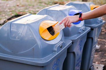 Selective focus. Recycle rubbish waste management people throwing plastic water bottle in the...
