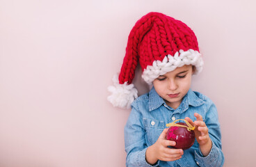 Baby boy in Santa Clause hat and Christmas tree toys