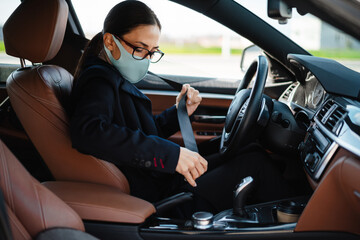 Business woman sitting in a car in face mask