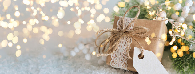 Christmas zero waste banner. Gift box packed in paper with tag for text and spruce branches on...