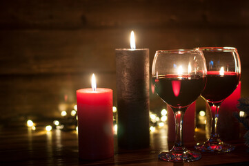 Wine in the grocery. Burning candles in the dark. The concept of Christmas and New Year comfort