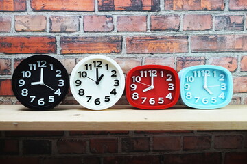 Clocks with time zone of different country on wooden shelves and brick wall background