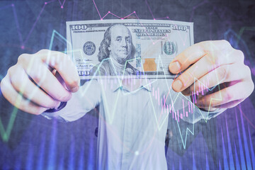 Multi exposure of forex graph drawing hologram and USA dollars bills and man hands. Technical Analysis concept.