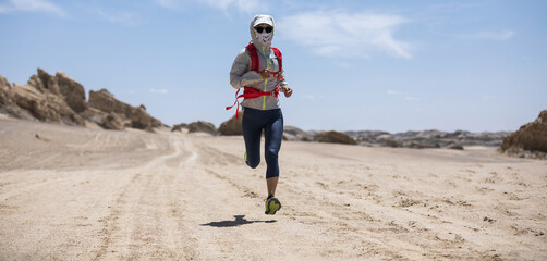 Fitness woman trail runner cross country running on sand desert