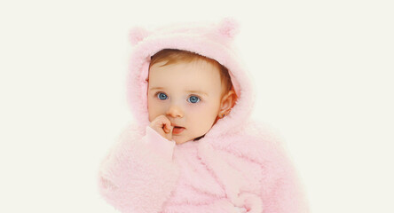 Portrait close up of sweet baby in pink bathrobe over a white background