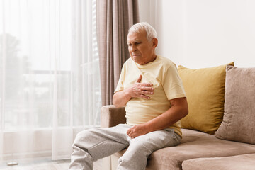 Senior man have pain in chest. Acid reflux or heart attack.