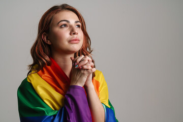 Focused beautiful woman wearing rainbow flag holding hands together