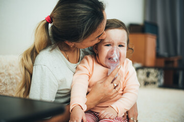 Mom makes inhalation of the child holding hands