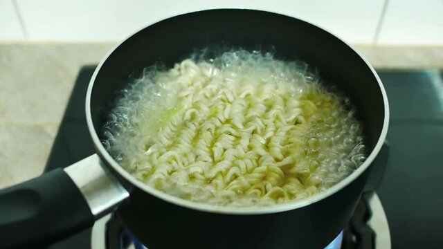 cooking instant noodles in boiling water, quick meal.