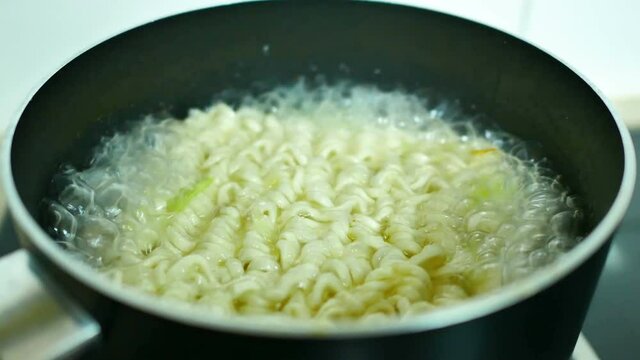 cooking instant noodles in boiling water, quick meal. close-up view.