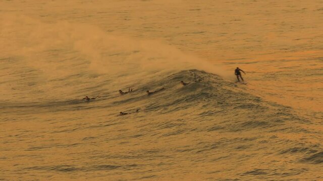 surfeando las olas surfista pasa muy cerca del resto de deportistas
