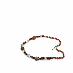 Women's bijouterie. Necklace made of terracotta, black and transparent beads of various shapes. Metal clasp. Isolated on white background.