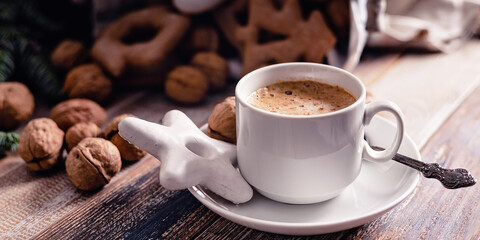 Food banner. Hot flavored nutty cappuccino with caramel and gingerbread Christmas cookies on a rustic table.