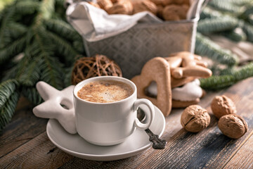 Hot flavored nutty cappuccino with caramel and gingerbread Christmas cookies on a rustic table....