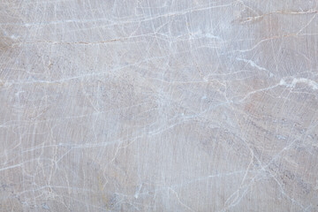 Grey stone surface with scratches and white veins