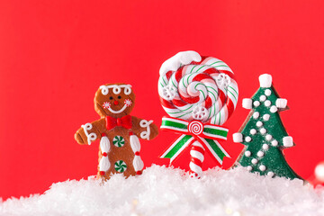Christmas Lollipop, Christmas tree, ginger man in the snow on a red background. Copy space. Christmas background.
