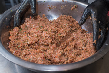 The chef mixes minced pork with different ingredients
