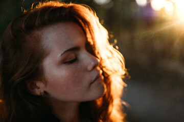 portrait of a red-haired young girl in autumn in the park with beautiful healthy red hair