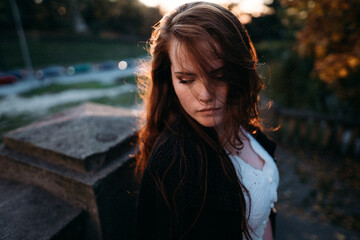red-haired young girl in autumn in the park with beautiful healthy hair