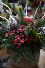 Beautiful arrangement from natural cones, red berries, spruce sprigs for festive interior...