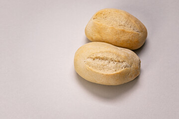 Appetizing French buns on a beige background. Fresh aromatic pastries. Copy space