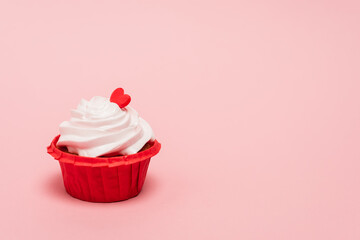 valentines cupcake with red heart on pink background