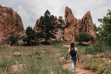 Scenic view of the large mountains on a cloudy summer day. Young woman is hiking at the park  with red mountains. Settlers park, Boulder, Colorado, USA. Denver