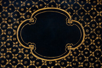 Golden floral frame painted on black wooden texture background