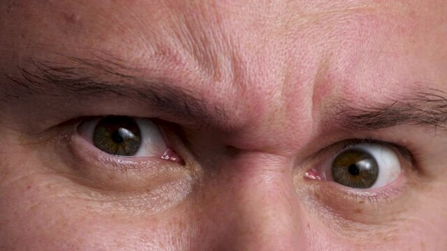 Man open hazel eyes and move eyebrows, be surprised. Male smile, positive emotion. Natural skin no make up. Wrinkle around eye is fold, ridge or crease on skin