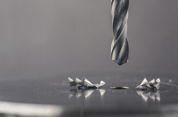 metal drill bit make holes in steel billet with lubricating liquid on industrial drilling machine....