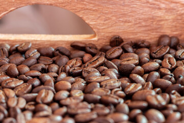 A wooden box full of roasted coffee beans.