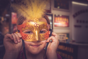 Young Caucasian girl with a carnival mask