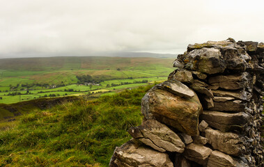 Rocks wall, and green hills farm. English countryside.