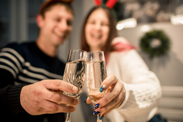 young couple congratulate merry christmas online. new year online.served table and glasses of champagne, white wine