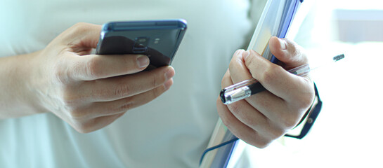 Datei und Telefon in der Hand der Frau
