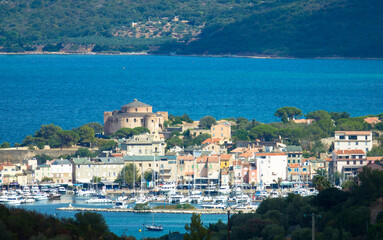 Panorama of beautiful Saint Florent fishing village, harbour and the citadel in the background. Corsica, France
