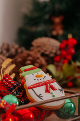 Christmas cookie in the shape of snowman in christmas setting.