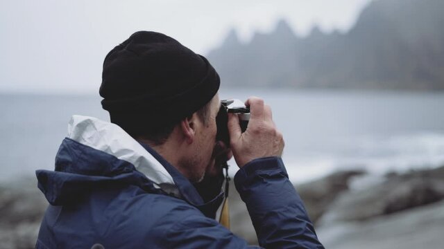 Hiker Focusing With Camera At Fjord