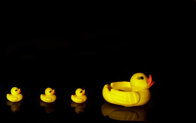 Yellow rubber ducks in rows on a black background